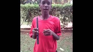 a senior one student at mackay memorial college playing a flute ( called omulele) in Uganda