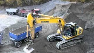 Komatsu PC 290 LC excavator loading a truck w/ trailer