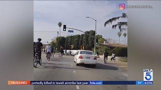 Mercedes-Benz swerves aggressively through crowd of cyclists blocking L.A. street