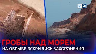 Доски гробов торчат из среза обрыва над Азовским морем на Кубани