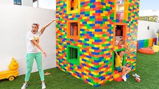 Vlad e Niki brincam com blocos de brinquedo coloridos e constroem uma casa de três níveis
