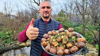 Country dinner of chicken and young potatoes in a cauldron on the fire.