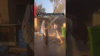 Because of extreme heat, cold water being sprayed on Zayareen walking towards Karbala for Arbaeen