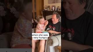 This little girl was very hungry so she snatch food from her grandpa