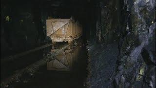 Climbing down to the mine carts in an abandoned mine