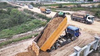 Massive Dump Truck Moving Dirt Unloading Building New Road In Town Motor Grader Paving Soil