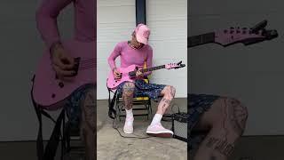 MGK playing his pink guitar 