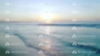 Sunset and soft sea on sandy evening beach blurred background for video transitions. Morning sunrise