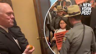 Pro-immigration protesters scream at Tom Homan while he nonchalantly chews on an apple