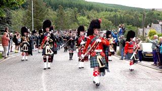 Massed pipes & drums parade through town to the 2019 Ballater Highland Games in Scotland