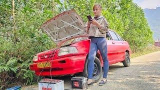 The girl repaired and restored the broken car in the middle of the road.