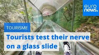 Watch: Tourists test their nerve on glass slide in China’s Shangluo