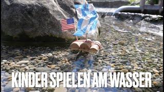 Kinder spielen am Wasser