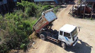 Many 6wheel truck and d20 bulldozer working unloading pushing rocks making filling up to Align sides