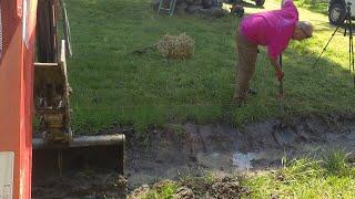 Mucking out a drainage ditch with mini excavator and a ditching bucket