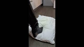 Shiny black boots crushing pillow