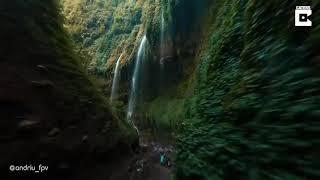 Drone flying through jungle waterfall