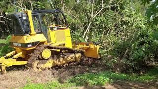 Caterpillar D5N dozer clearing some weeds