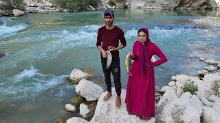 Nomadic young couple fishing by the river , 2023 iran