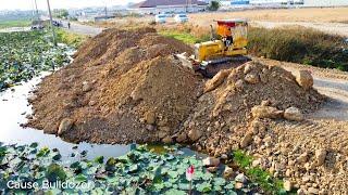 Dump trucks 10Ton open work stone soil into the lake process with KOMATSU D31P Dozer push & Clear