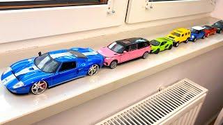 Bigger and Small Diecast model cars driven by hand on the windowsill