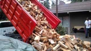 Dangerous dump truck unloading wood.