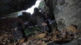 Survivor on the mountains, overnight in a 10 meters deep cave. Cooking over the fire on a stone slab