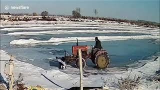 Man driving tractor falls through ice into pond when clearing snow in China