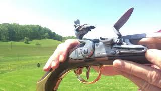 Military heritage 1733 flintlock pistol shooting clay ball at a steel target 