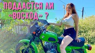 The girl starts an old Russian motorcycle "Voskhod 3M-01"