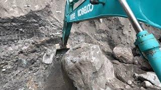 The excavator used all its strength to push the huge rock