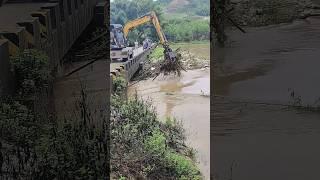 Excavator clears floating garbage from the river