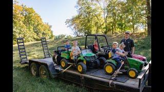 kids loading and helping strap down their power wheels on the trailer to drive on the farm!