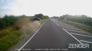 This video shows a car crashing into a ditch as it overtakes a lorry