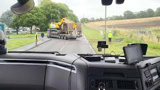 Just a man with a lowloader putting a machine in a field