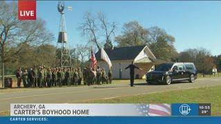 Former President Jimmy Carter's hearse arrives at his childhood home in Georgia