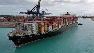 Freight Container ship getting Tugged around the MSC Divina in Freeport, Bahamas by two Tug Boats