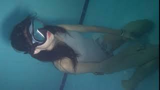 girl underwater breathholding in bottom of 5m pool