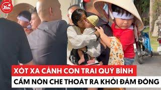 Xót xa cảnh con trai Quý Bình cầm nón che mặt, được người nhà bế thoát khỏi đám đông