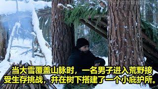 当大雪覆盖山脉时，一名男子进入荒野接受生存挑战，并在树下搭建了一个小庇护所。 | 在野外生存