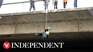 Climate activist hangs from Adelaide bridge during Extinction Rebellion protest