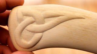 Simple wood carving.  Scandinavian ornament on the handle of an ax