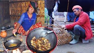 jungle man weaving basket and wife is cooking wild mushroom curry rice for him