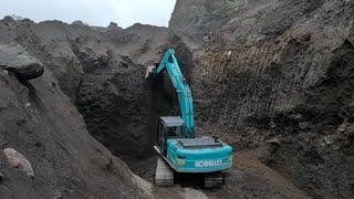 excavator digs hard sand in sand mine