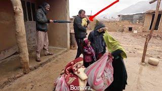 The displacement of a nomadic family with an infant under the winter rain by a cruel man