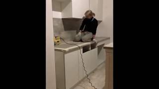 Блондинка устанавливает кухонную мойку в столешницу